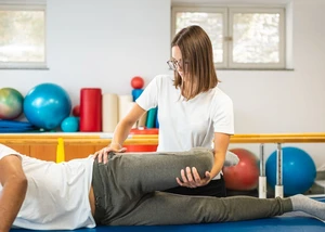 Physiotherapeutin macht Beinübungen mit Patient 24K-Production/ Adobe Stock