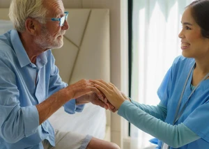 Pflegekraft und Patient halten Hände ake1150/ Adobe Stock