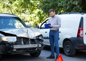 Gutachter für Autos prüft ein zerstörtes Auto nach einem Verkehrsunfall. Zerbrochene, beschädigte vordere Autofront bei einem Autounfall Gutachter für Autos prüft ein zerstörtes Auto nach einem Verkehrsunfall. Zerbrochene, beschädigte vordere Autofront bei einem Autounfall