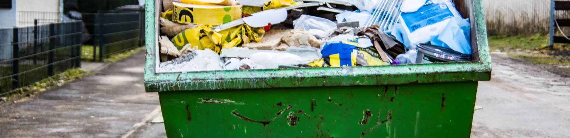 Grüner Abfallcontainer am Straßenrand